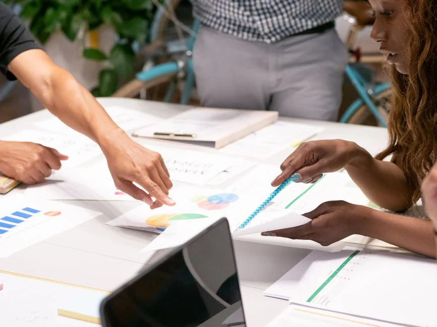 who-we-are Vue de dessus d’un graphique e-commerce avec un smartphone, une calculatrice et une loupe posés sur une table.